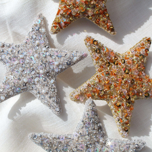 Decorative star-shaped ornaments with sequins on a light background