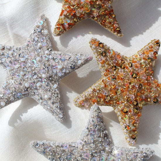 Decorative star-shaped ornaments with sequins on a light background